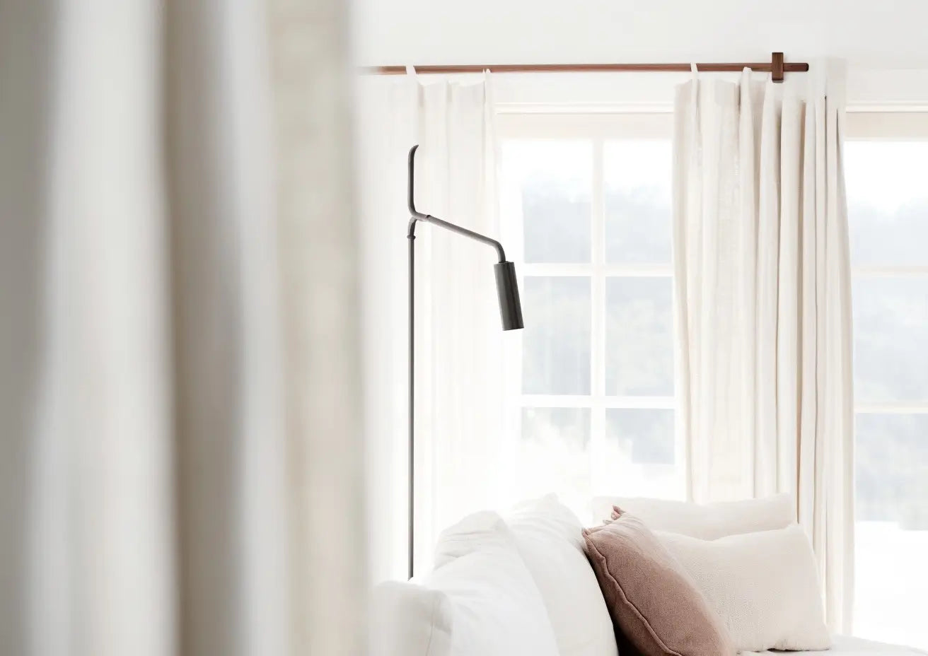 White wall-mounted wood rod with sheer curtains