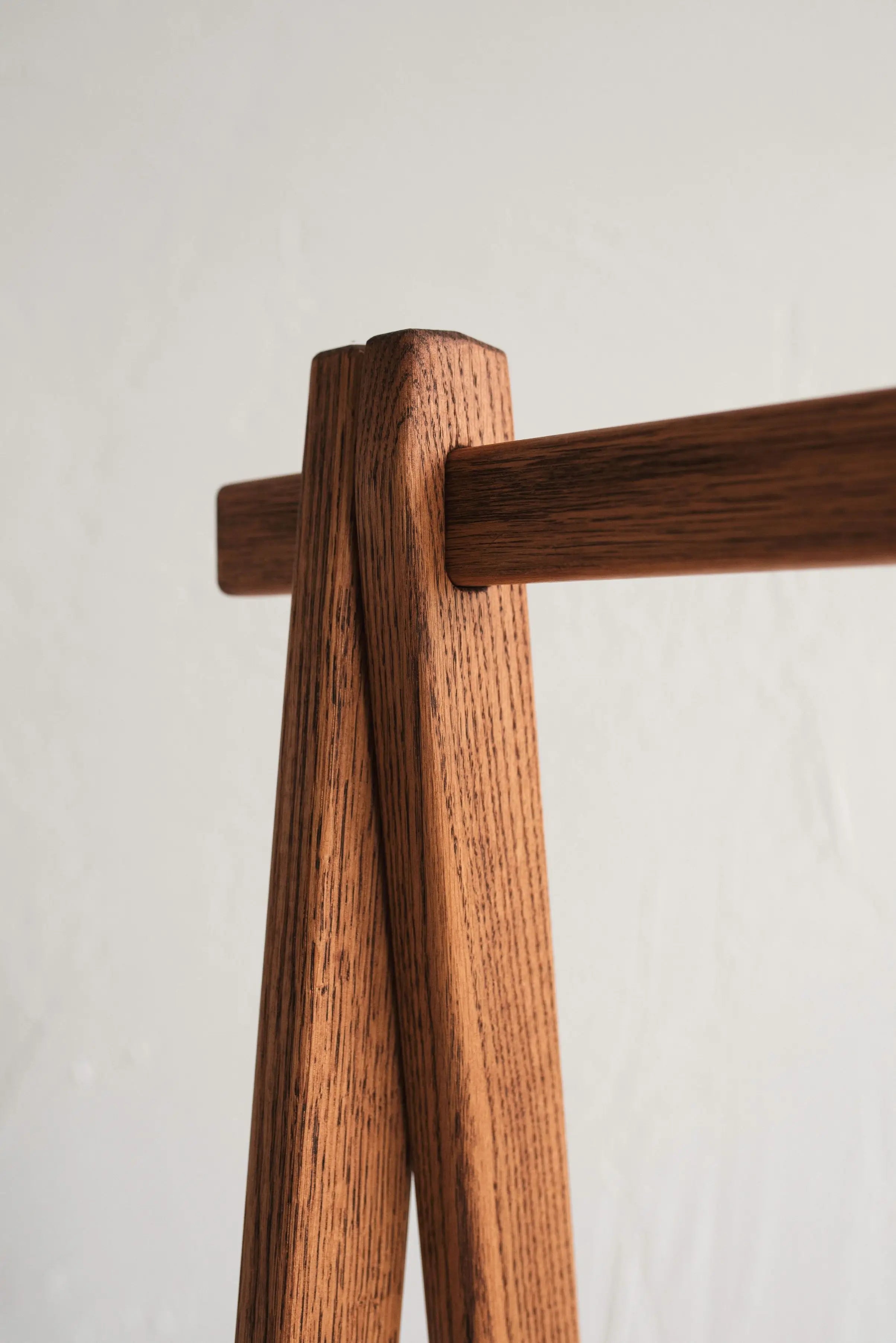 Close-up of a wooden coat rack with two hooks on a light background