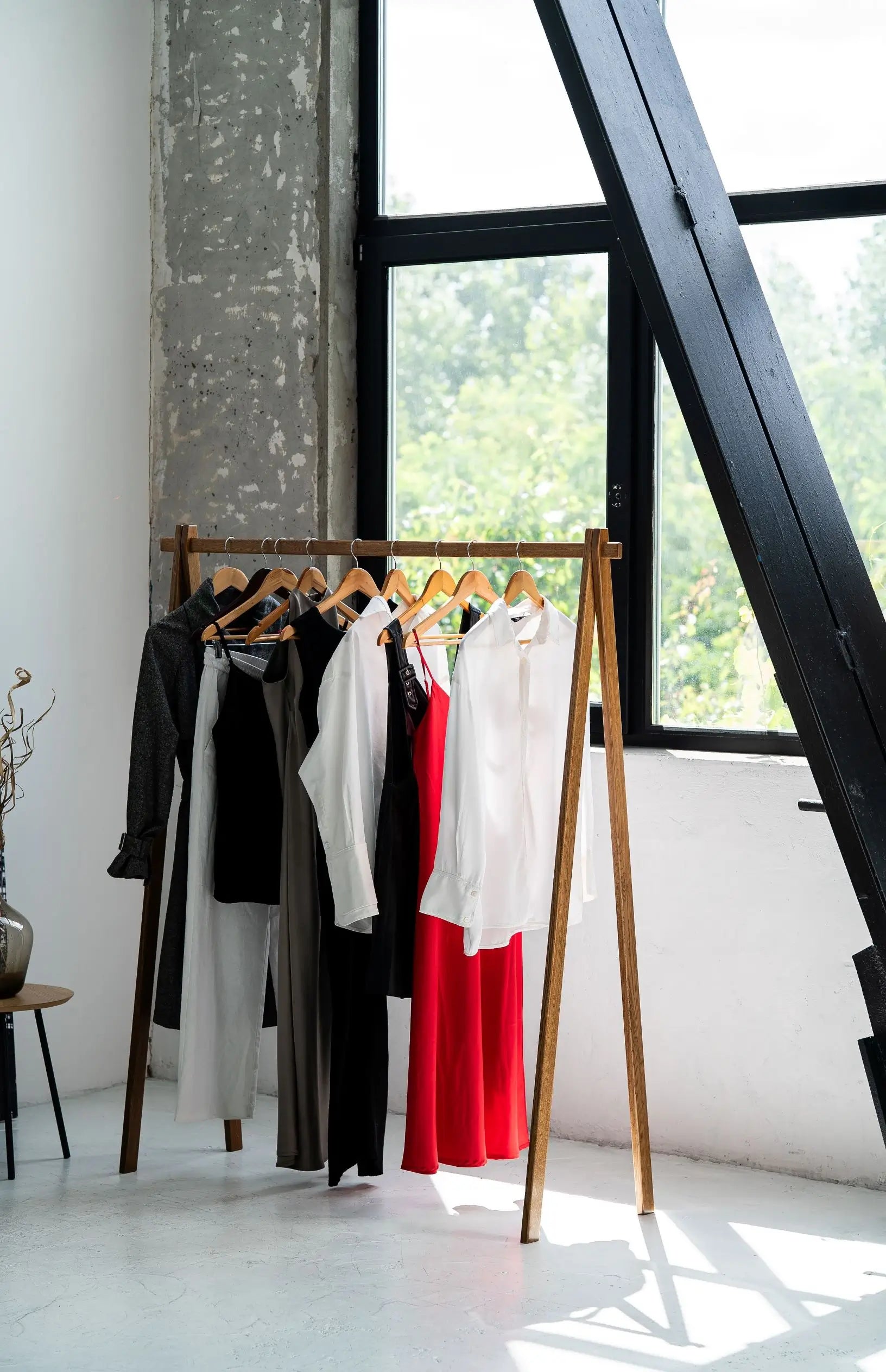 Clothing rack with clothes in a room with large windows