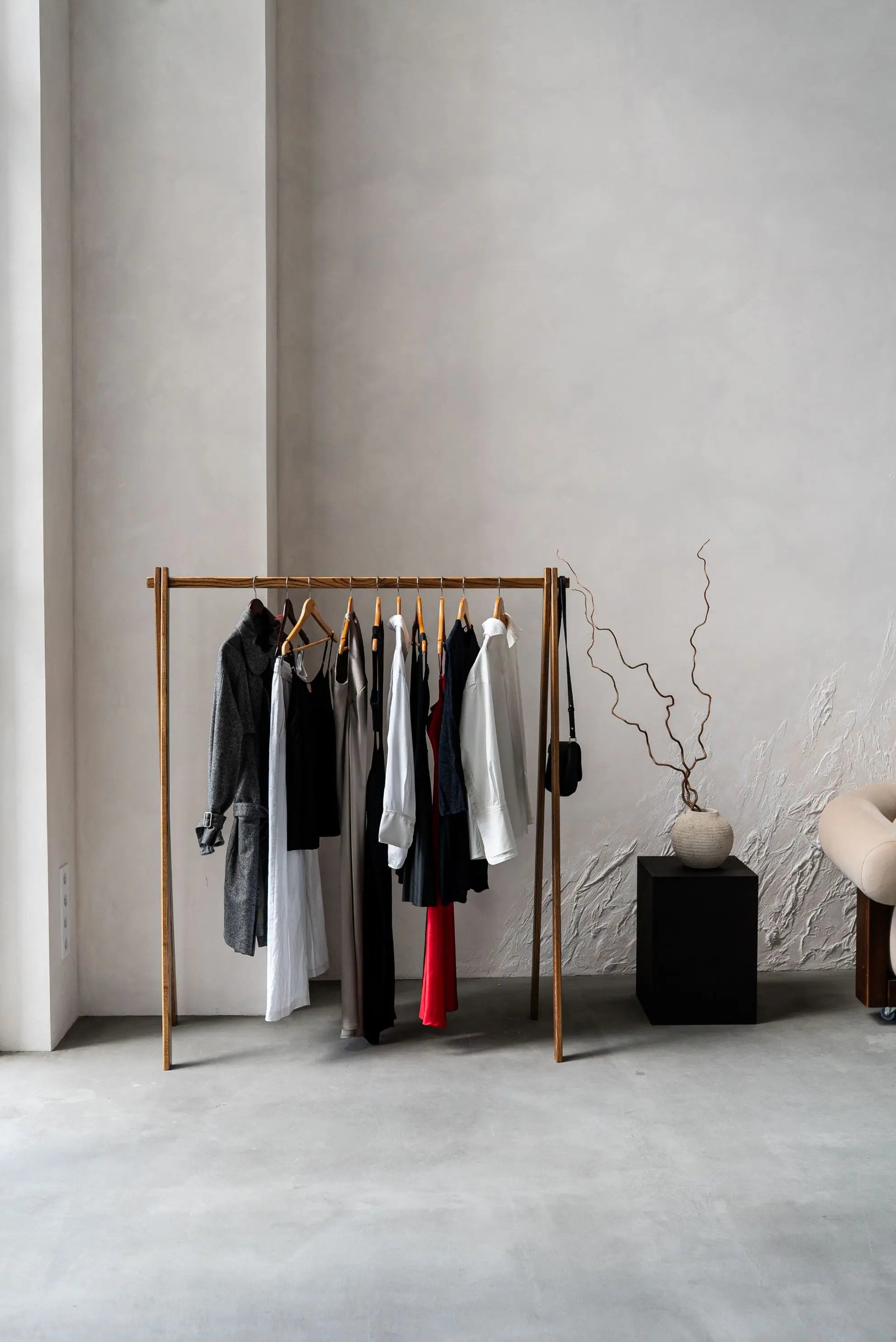 Clothing rack with clothes against a plain wall