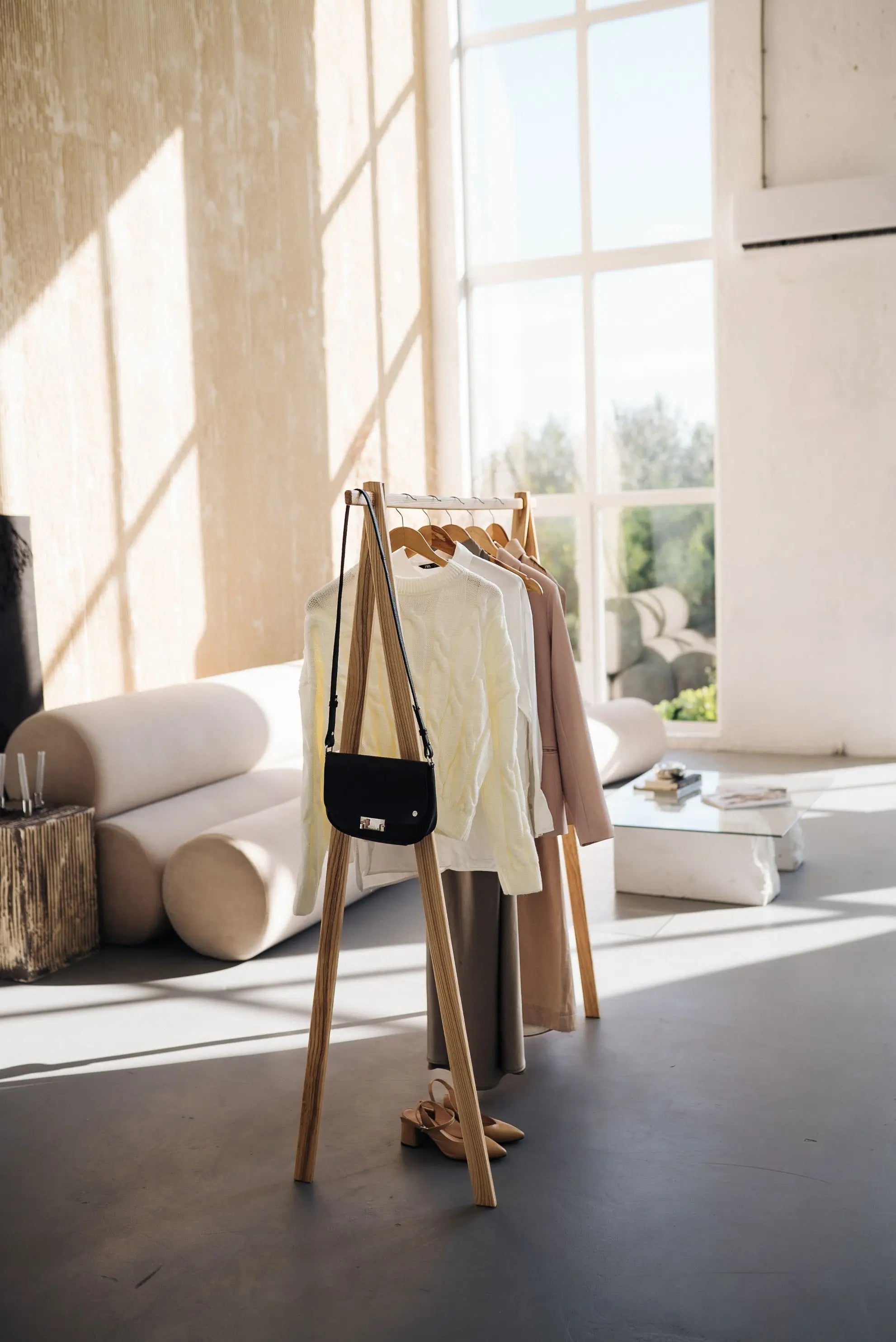 Clothing rack with clothes in a bright room with large windows