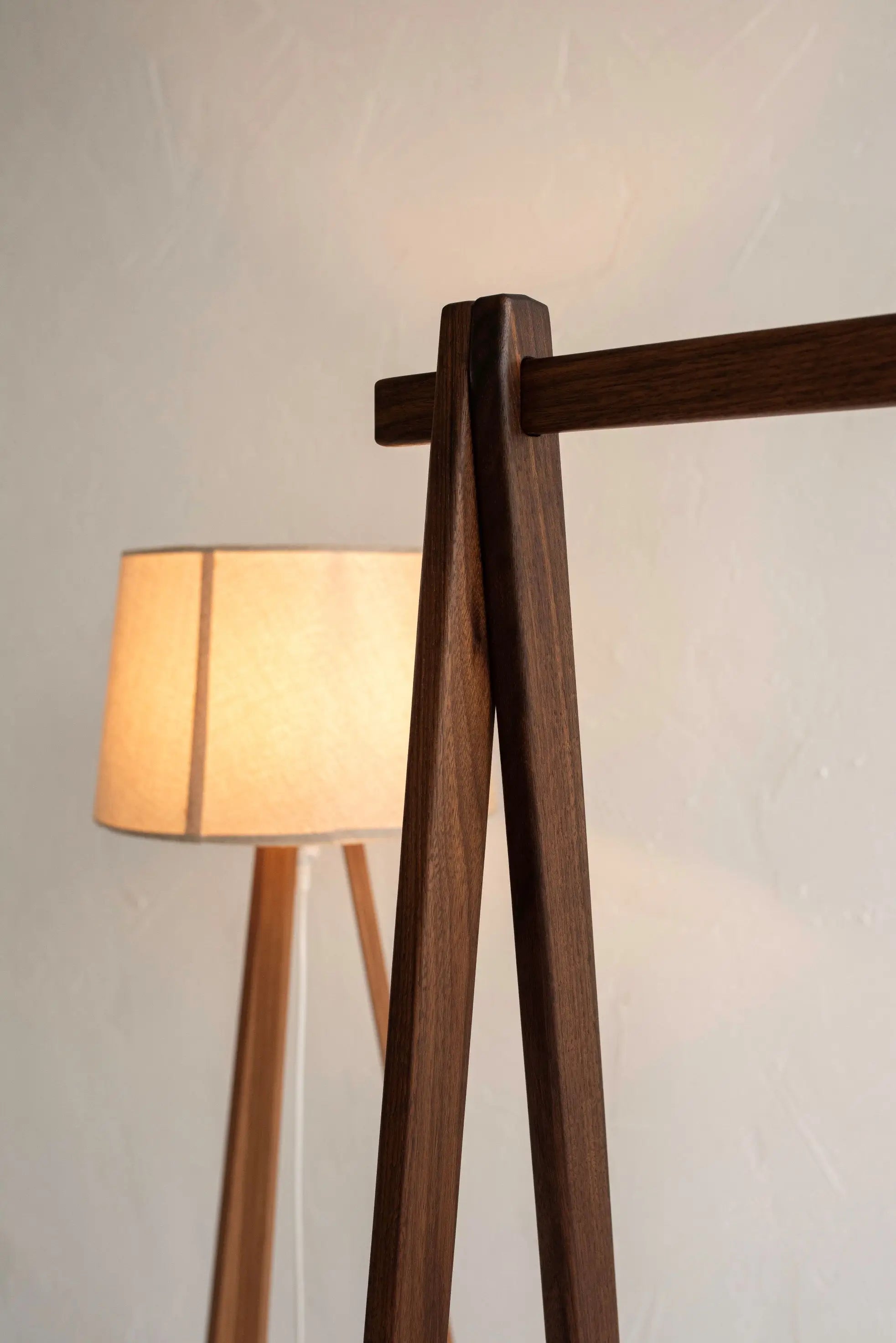 Wooden floor lamp with a soft glow against a plain background