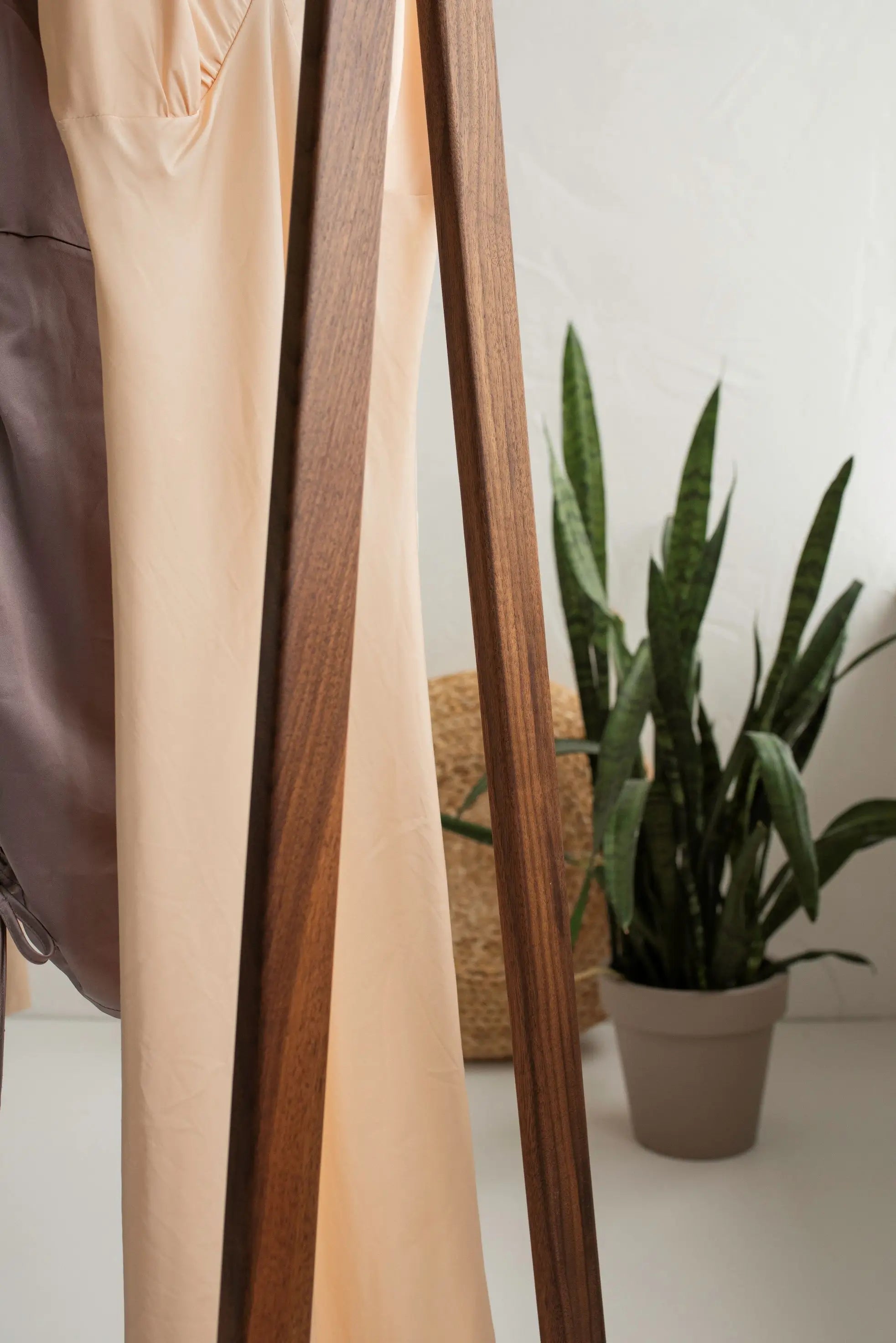 Close-up of a person wearing a beige outfit with a plant in the background
